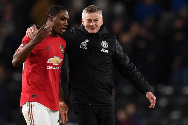 Manchester United’s Norwegian manager Ole Gunnar Solskjaer (R) talks to striker Odion Ighalo (Photo by OLI SCARFF/AFP via Getty Images)