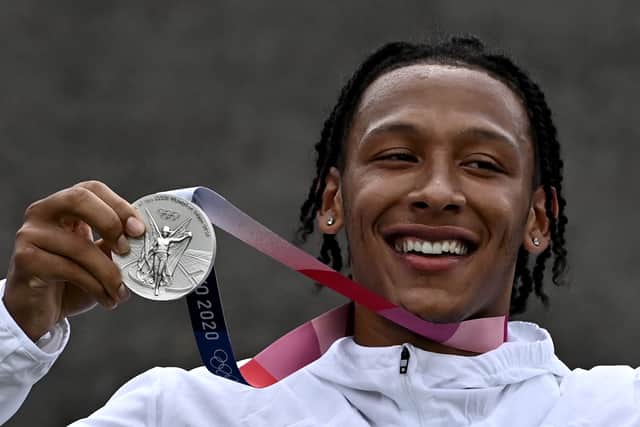 Britain’s Kye Whyte celebrates on the podium for the victory ceremony for the cycling BMX racing men’s event. Credit: JEFF PACHOUD/AFP via Getty Images