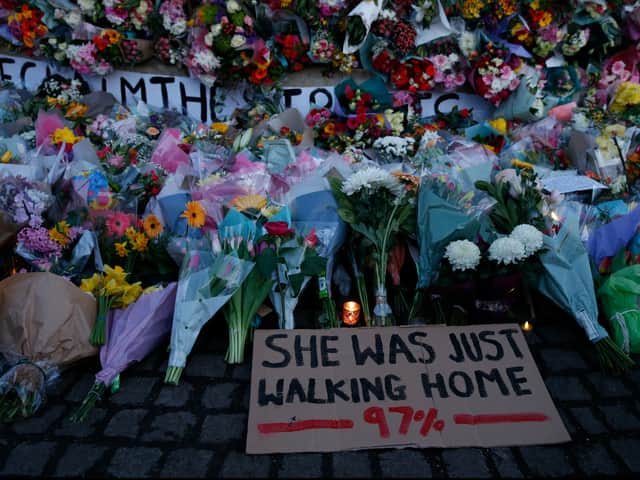 A sign saying “SHE WAS JUST WALKING HOME 97%” among the flowers and candles on Clapham Common for Sarah Everard. Photo by Hollie Adams/Getty Images 