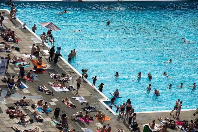 Sunbathers fill the edges of busy outdoor swimming pool Brockwell Lido in Brockwell Park. Credit: Chris J Ratcliffe/Getty Images