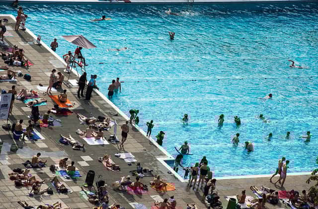 Sunbathers fill the edges of busy outdoor swimming pool Brockwell Lido in Brockwell Park. Credit: Chris J Ratcliffe/Getty Images