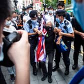 Activist Alexandra Wong (C), also known as Grandma Wong, is taken away by police while protesting on the 24th anniversary of Hong Kong's handover from Britain, in Hong Kong on July 1, 2021. (Photo by ISAAC LAWRENCE / AFP) (Photo by ISAAC LAWRENCE/AFP via Getty Images)