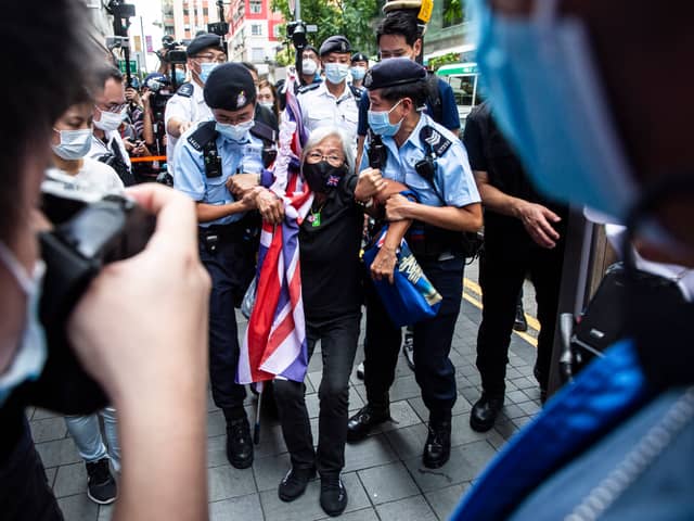 Activist Alexandra Wong (C), also known as Grandma Wong, is taken away by police while protesting on the 24th anniversary of Hong Kong's handover from Britain, in Hong Kong on July 1, 2021. (Photo by ISAAC LAWRENCE / AFP) (Photo by ISAAC LAWRENCE/AFP via Getty Images)