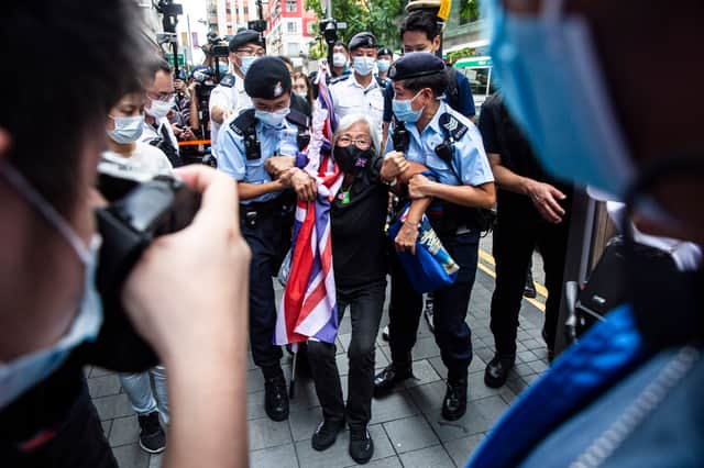 Activist Alexandra Wong (C), also known as Grandma Wong, is taken away by police while protesting on the 24th anniversary of Hong Kong's handover from Britain, in Hong Kong on July 1, 2021. (Photo by ISAAC LAWRENCE / AFP) (Photo by ISAAC LAWRENCE/AFP via Getty Images)