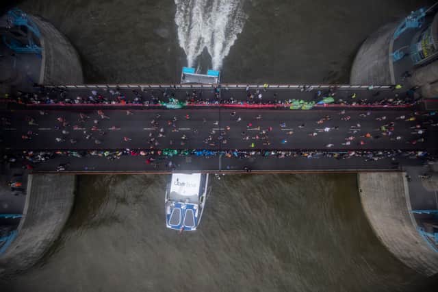 Runners cross Tower Bridge during the London Marathon as a boat passes underneath on October 03, 2021 in London, England. (Photo by Rob Pinney/Getty Images)