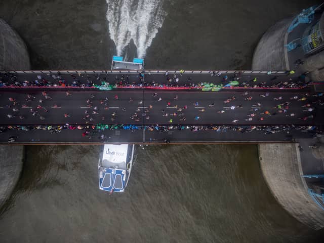Runners cross Tower Bridge during the London Marathon as a boat passes underneath on October 03, 2021 in London, England. (Photo by Rob Pinney/Getty Images)