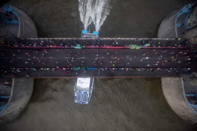 <p>Runners cross Tower Bridge during the London Marathon as a boat passes underneath on October 03, 2021 in London, England. (Photo by Rob Pinney/Getty Images)</p>
