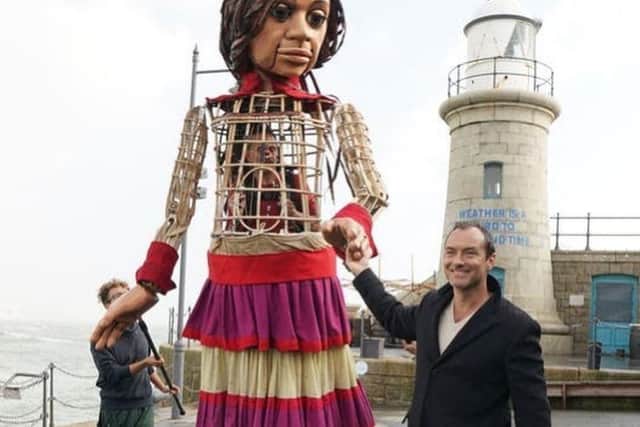 Jude Law with puppet Little Amal, which has arrived from the Syrian border to the UK. There will be events across London next week. Credit: Simon Annand