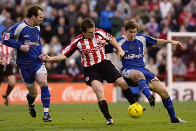 Jay Tabb of Brentford holds off Steve Jenkins (L) and Grant Smith of Swindon Town during the Coca-Cola First Division match (Photo by Ker Robertson/Getty Images)