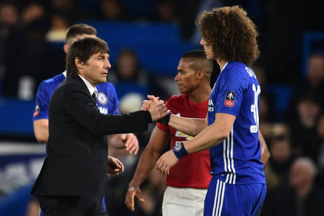 Chelsea's Italian head coach Antonio Conte (L) shakes hands with Chelsea's Brazilian defender David Luiz (Photo credit should read GLYN KIRK/AFP via Getty Images)