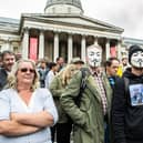 Protesters wearing anonymous masks in Trafalgar Square calling for lockdown rules to be removed