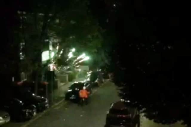 A firework explodes by the delivery driver in a residential street in Hackney. Credit: SWNS