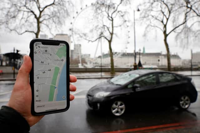 A man using Uber in London. Credit: TOLGA AKMEN/AFP via Getty Images