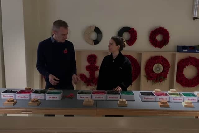Richmond Poppy Factory communications manager Dan Hodges shows reporter Claudia Marquis how to make poppies. Credit: Local TV