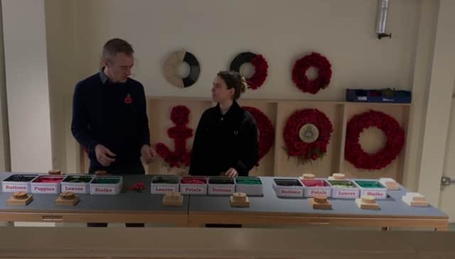 Richmond Poppy Factory communications manager Dan Hodges shows reporter Claudia Marquis how to make poppies. Credit: Local TV