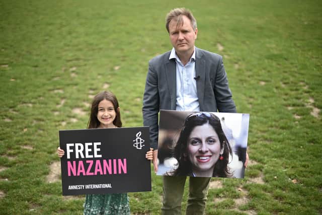 Richard Ratcliffe (R) and his daughter Gabriella pose with placards of Nazanin in Parliament Square to mark the 2,000th day of her detention in Iran on September 23 (Photo by DANIEL LEAL-OLIVAS/AFP via Getty Images)