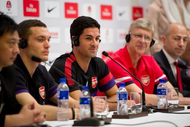 Footballers Thomas Vermaelen (2nd L), Mikel Arteta (C) and manager Arsene Wenger (2nd L) of English football team Arsenal (Photo credit should read Ed Jones/AFP/GettyImages)