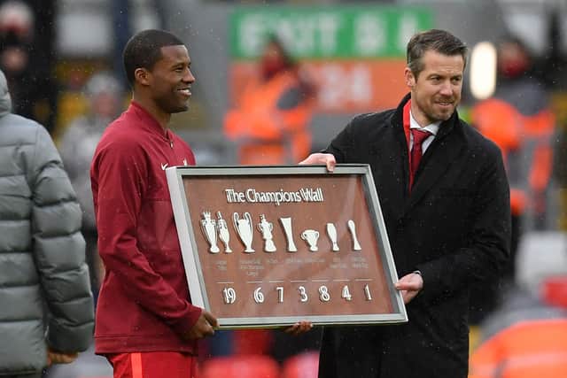 Liverpool’s Dutch midfielder Georginio Wijnaldum (L) is presented with a plaque following his final game (Photo by PAUL ELLIS/POOL/AFP via Getty Images)