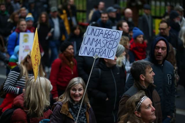 “Freedom march” protestors against vaccines, vaccine passports, lockdowns march near Victoria Station on December 18. Credit: Hollie Adams/Getty Images