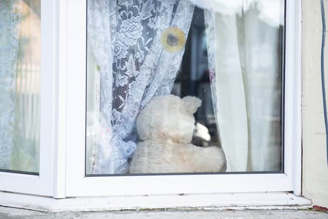Teddy bears in the windows of a home where a man and woman have been found dead. Credit: Tony Kershaw / SWNS