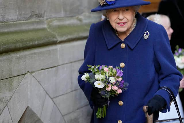 Queen Elizabeth II receives flowers as she leaves after attending a service of Thanksgiving to mark the centenary of The Royal British Legion at Westminster Abbey on October 12, 2021 in London, England.