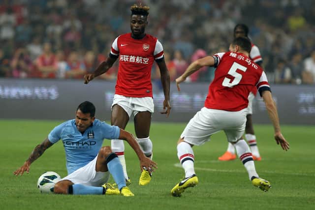 Tevez (L) of Manchester City in action with Alexandre Song (C) and Vermaelen (R) of Arsenal FC (Photo by Gu Zhichao/Sports Illustrated China/Getty Images)