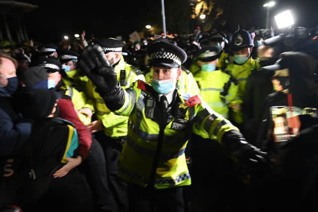 Police officers scuffle with well-wishers  as they gather at a band-stand where a planned vigil in honour of alleged murder victim Sarah Everard was cancelled after police outlawed it due to Covid-19 restrictions. Credit:  Leon Neal/Getty Images