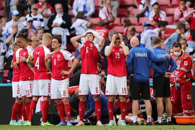 Denmark’s players react as paramedics attend to Denmark’s midfielder Christian Eriksen after he collapsed on the pitch. Credit: FRIEDEMANN VOGEL/POOL/AFP via Getty Images