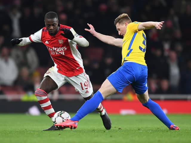 Nicolas Pepe of Arsenal takes on Tom Flanagan of Sunderland during the Carabao Cup Quarter Final match between Arsenal and Sunderland at Emirates Stadium on December 21, 2021 in London, England