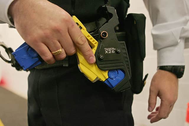 A police officer holsters a taser gun during a training session at the Metropolitan Police Specialist Training Centre. Credit: CARL DE SOUZA/AFP via Getty Images
