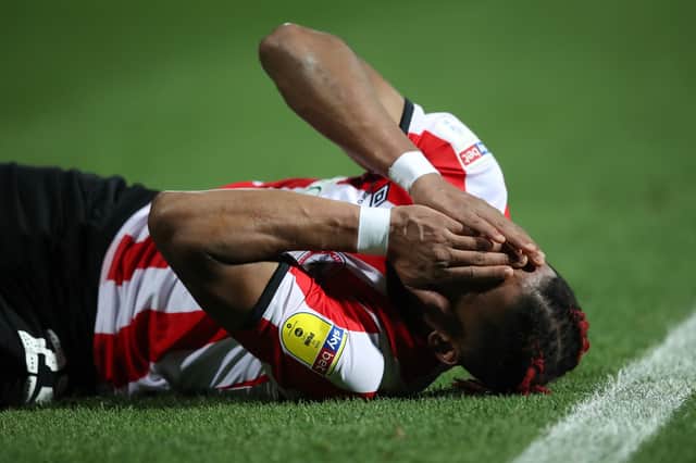Julian Jeanvier of Brentford holds his face  (Photo by Alex Pantling/Getty Images)