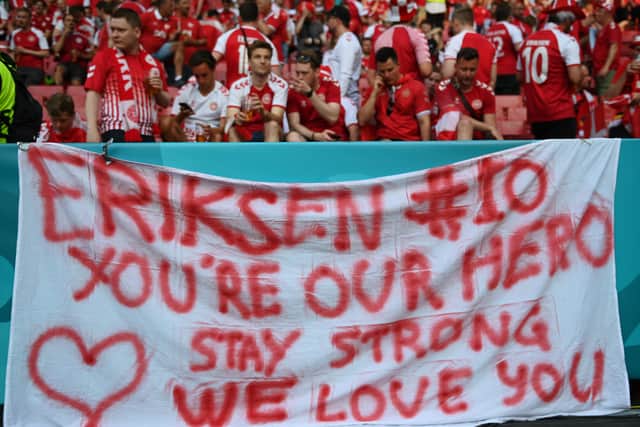Fans of Denmark place a flag out with a message of love and support for Christian Eriksen (Photo by Stuart Franklin/Getty Images)