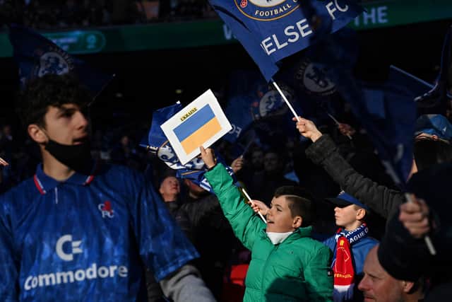 Chelsea supporters hold up Ukrainian flags in the crowd ahead of the English League Cup . (Photo by GLYN KIRK/AFP via Getty Images)