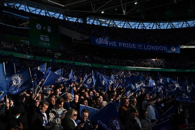 Chelsea players wave flags ahead of the English League Cup final football match (Photo by GLYN KIRK/AFP via Getty Images)