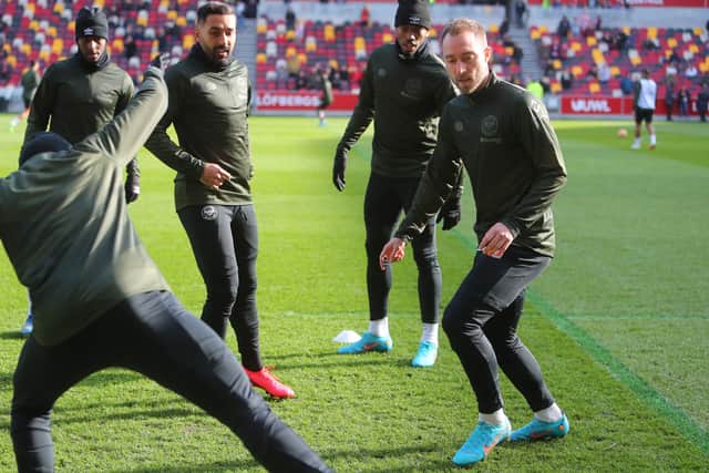  Danish midfielder Christian Eriksen (R) warms up with teammates ahead of the English Premier League (Photo by GEOFF CADDICK/AFP via Getty Images)