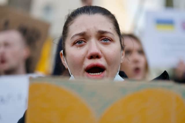 A demonstrator cries holding a placard at a rally staged in front of the Downing Street gates, in central London. Credit: TOLGA AKMEN/AFP via Getty Images