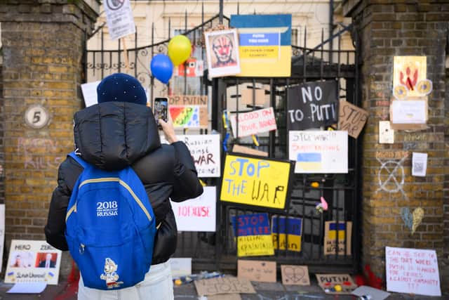 A person wearing a Russia 2018 World Cup bag looks at the graffiti-covered wall of the Russian embassy on February 26, 2022 in London. Photo: Getty