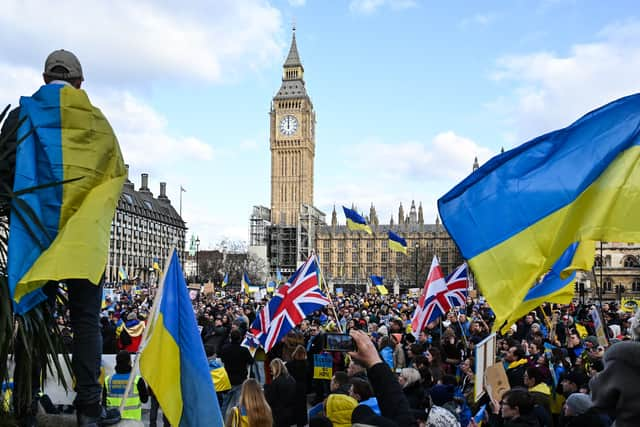 Demonstrators hold placards, Ukrainian and British flags during a protest rally in London in support of Ukraine. Photo: Getty