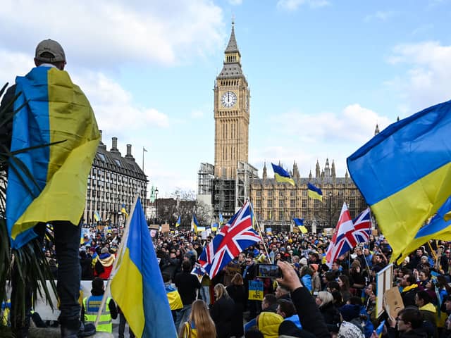 Demonstrators hold placards, Ukrainian and British flags during a protest rally in London in support of Ukraine. Photo: Getty
