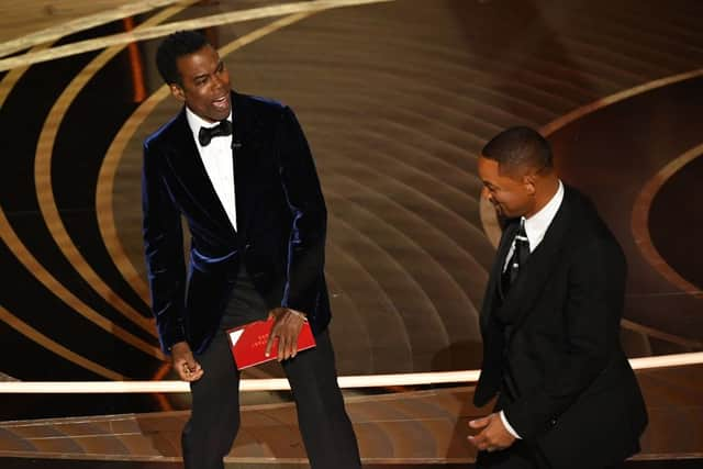 US actor Will Smith (R) approaches US actor Chris Rock onstage during the 94th Oscars at the Dolby Theatre in Hollywood, California on March 27, 2022. (Photo by Robyn Beck / AFP) 