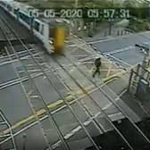 The daredevil is inches away from being flattened by the Thameslink train. Credit: SWNS