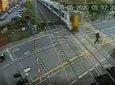 The daredevil is inches away from being flattened by the Thameslink train. Credit: SWNS