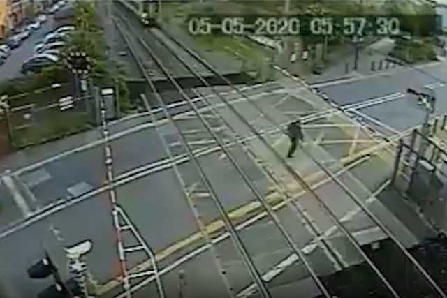 The man almost makes it across the Brimsdown crossing, before the train hurtles into view. Credit: SWNS