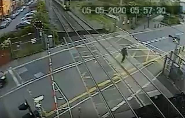 The man almost makes it across the Brimsdown crossing, before the train hurtles into view. Credit: SWNS