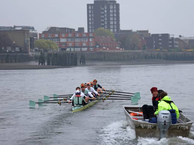 The Cambridge University men's boat are trailed by their coach as they train early in the morning on the River Thames in London on March 30, 2022, 