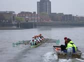 The Cambridge University men's boat are trailed by their coach as they train early in the morning on the River Thames in London on March 30, 2022, 