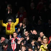 Brentford’s fans celebrate during the English Premier League football match between Chelsea and Brentford at Stamford Bridge  (Photo by GLYN KIRK/AFP via Getty Images)