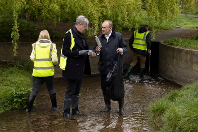 Liberal Democrat leader Ed Davey is shown a piece of previously collected rubbish while standing in the River Wandle at Wandle Park. Photo: Getty