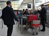 Airline staff manage holidaymakers and travellers as they queue at a check-in desk in the departure hall of Terminal 2 at London Heathrow Airport in west London, on April 6, 2022. (Photo by JUSTIN TALLIS/AFP via Getty Images)