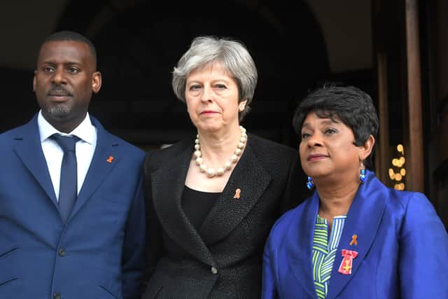 Theresa May standing with Stephen Lawrence’s brother Stuart and mother Doreen at the 25th anniversary of his death (Photo: VICTORIA JONES/AFP via Getty Images))